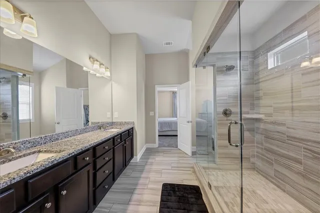 a bathroom with a granite countertop sink a large mirror and cabinets
