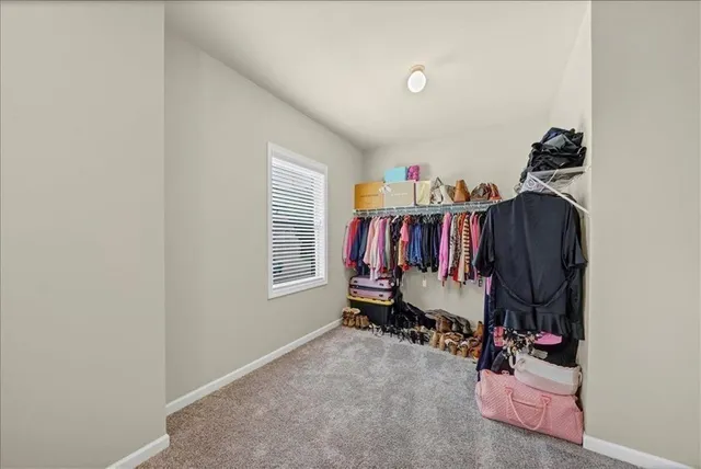 a view of walk in closet with clothes