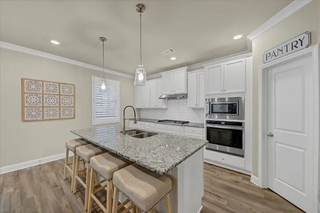 a kitchen with stainless steel appliances granite countertop a sink a stove and a refrigerator