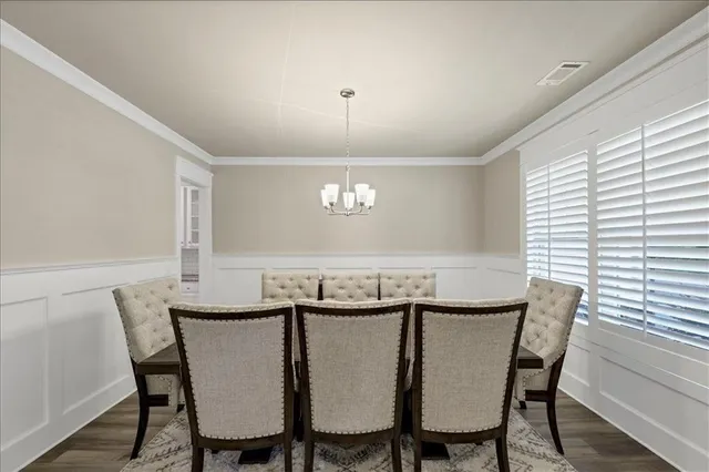 a view of a dining room with furniture and chandelier