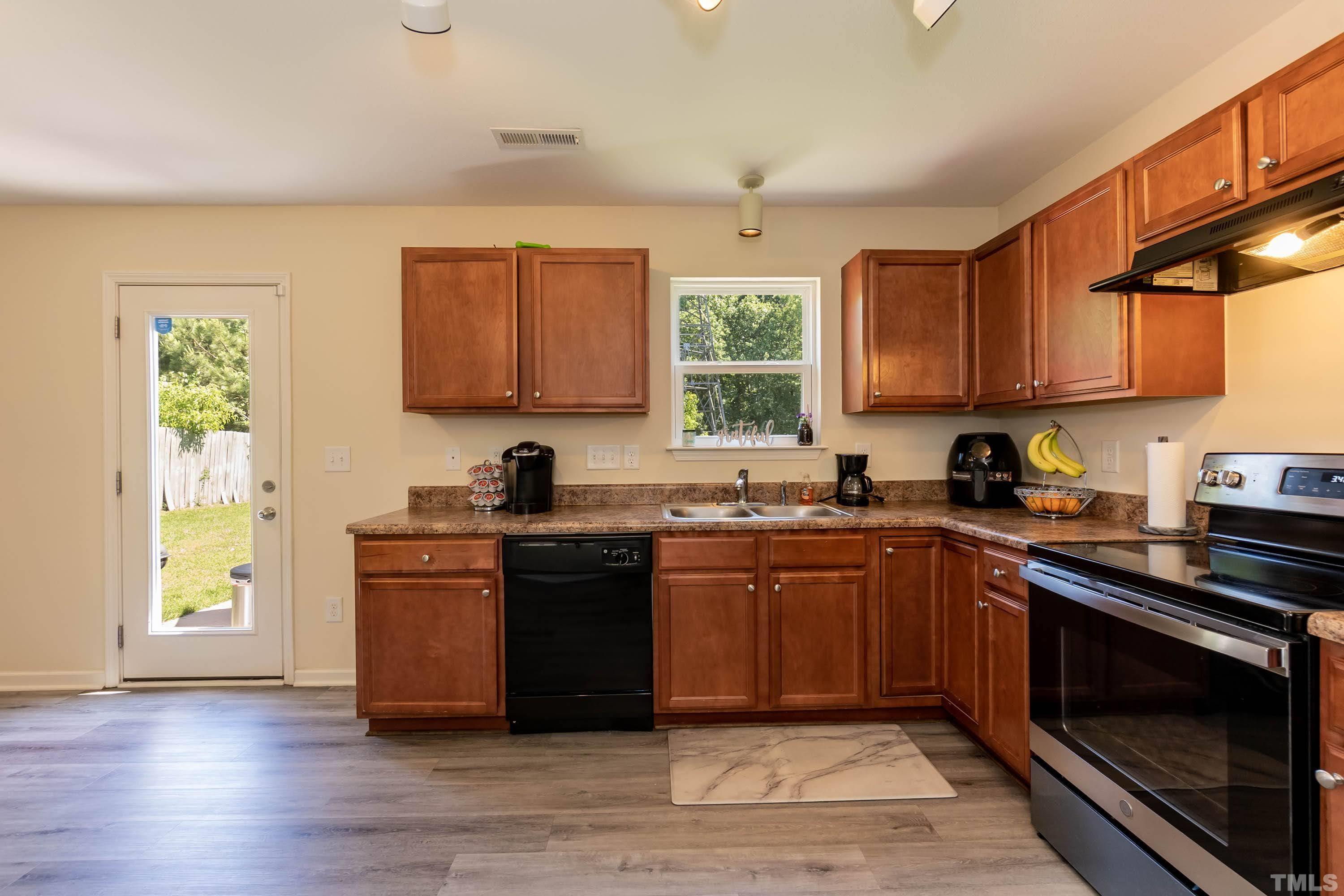 4108 Lady Slipper Lane Durham, NC 27704 - Photo 13 of 33 a kitchen with stainless steel appliances granite countertop a stove a sink dishwasher and a microwave oven with cabinets