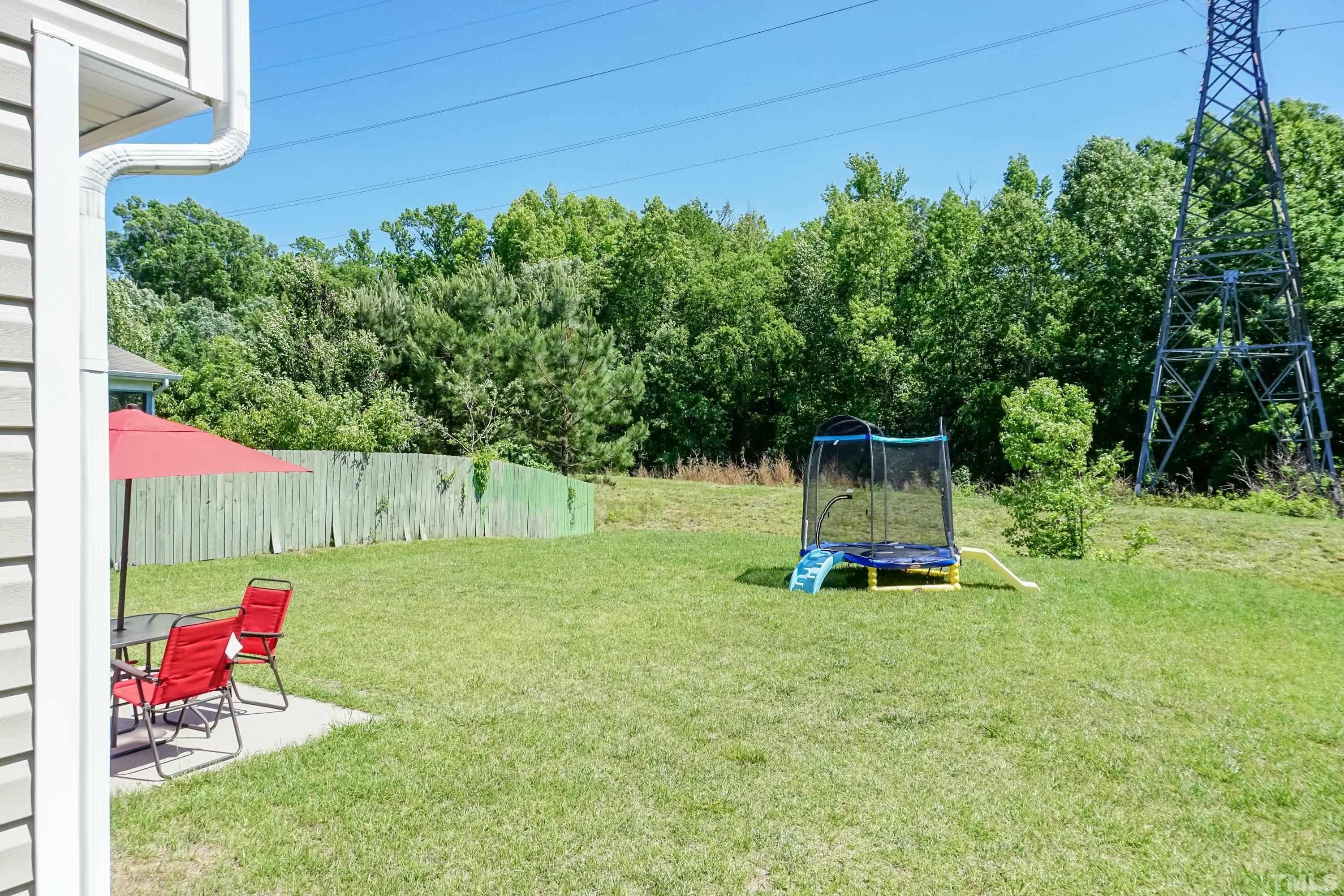 4108 Lady Slipper Lane Durham, NC 27704 - Photo 27 of 33 a view of a backyard with a slide trees and wooden fence