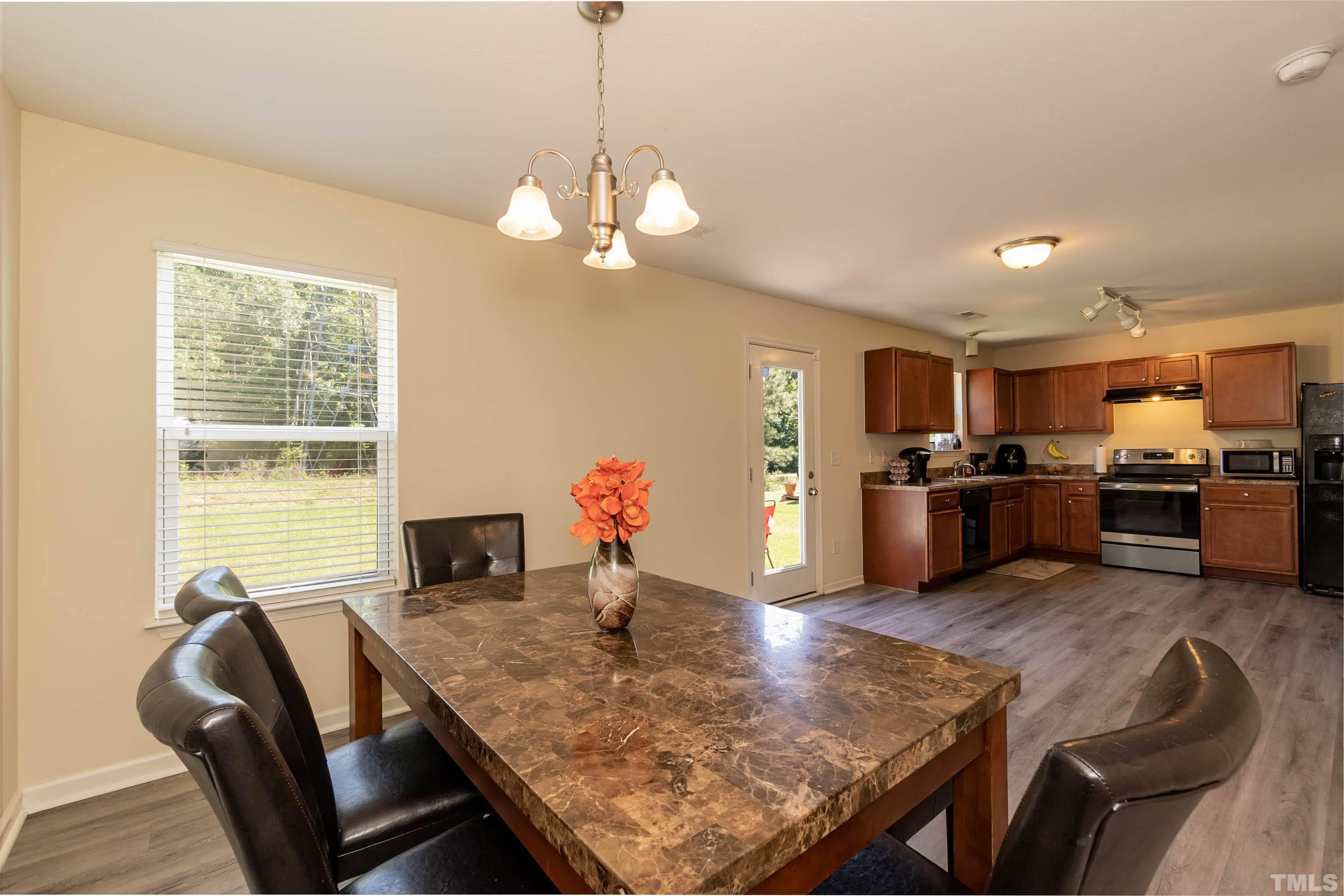4108 Lady Slipper Lane Durham, NC 27704 - Photo 10 of 33 a view of a dining room and livingroom with furniture wooden floor a chandelier