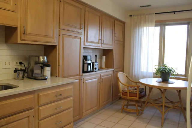 a kitchen with appliances cabinets and chair