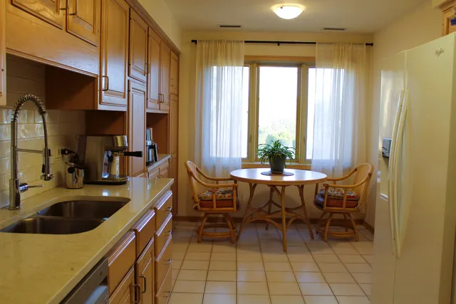 a dining room with stainless steel appliances a table and chairs