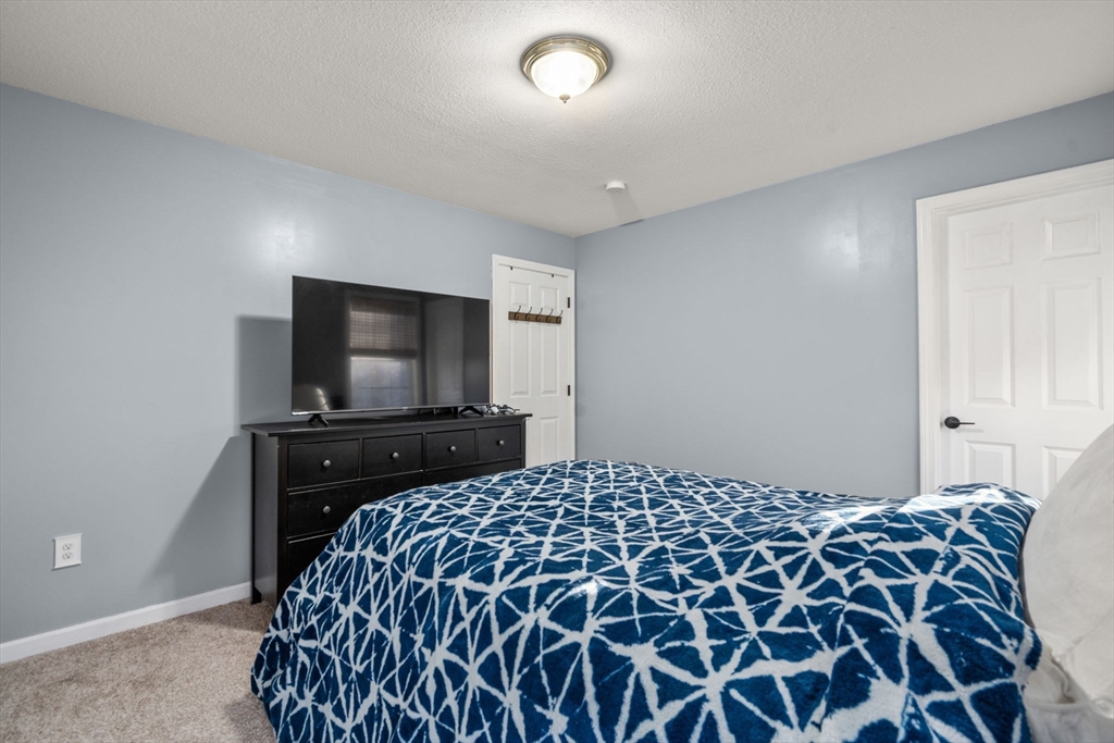 89 Jarvis Avenue Holyoke, MA 01040 - Photo 18 of 27 a bedroom with a bed and a flat screen tv