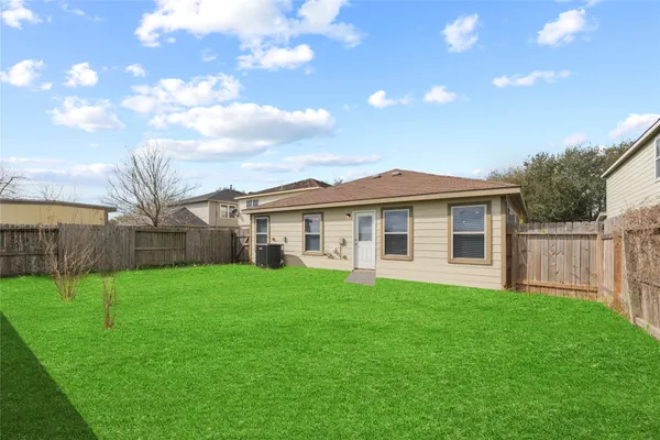 a view of a yard in front of a house with a big yard and large trees