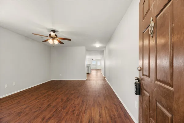 a view of empty room with wooden floor