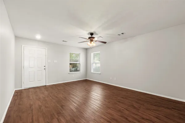 a view of a room with wooden floor and a ceiling fan