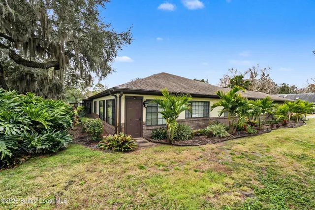 a view of a house with a yard and potted plants