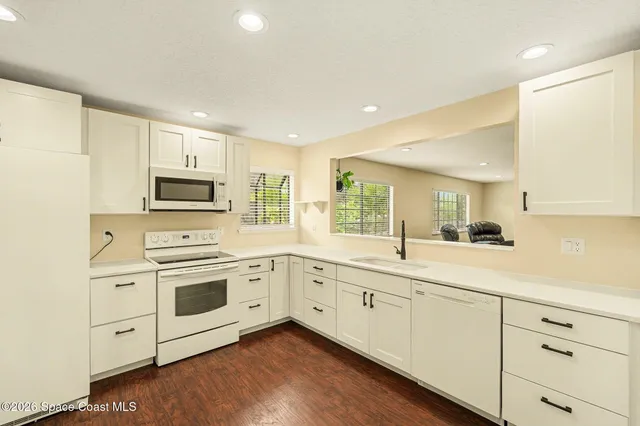 a kitchen with white cabinets sink and white appliances