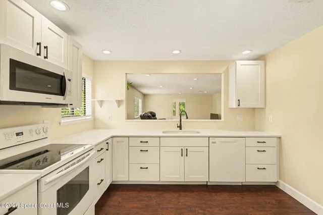 a kitchen with white cabinets sink and stainless steel appliances
