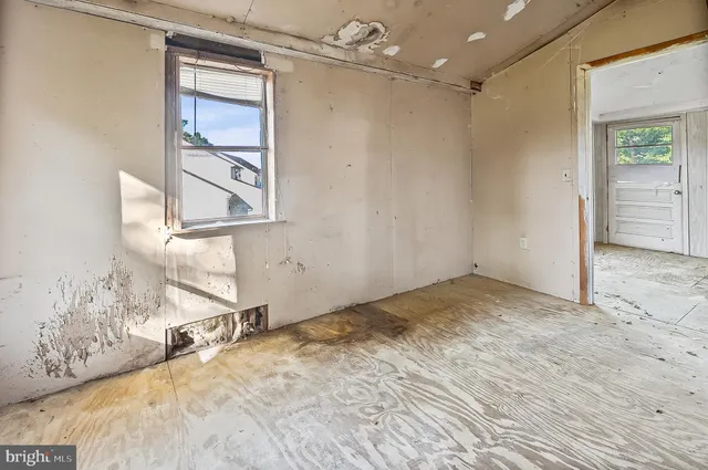 a view of a livingroom with wooden floor and a bathroom