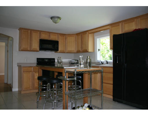 193 Oxbow Road Wayland, MA 01778 - Photo 7 of 20 a kitchen with a sink a microwave a refrigerator and cabinets