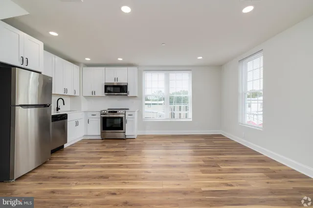 a view of kitchen with granite countertop stainless steel appliances and window