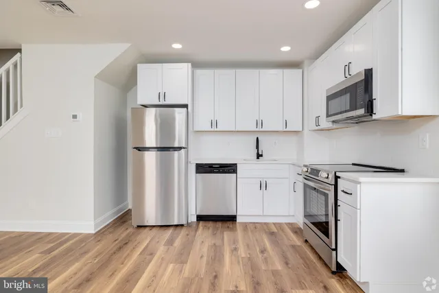 a kitchen with stainless steel appliances granite countertop a refrigerator stove a sink and a microwave