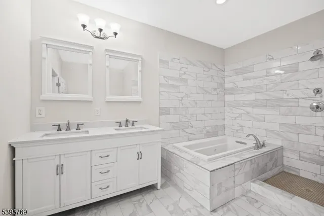 a spacious bathroom with a double vanity sink a mirror and a bathtub