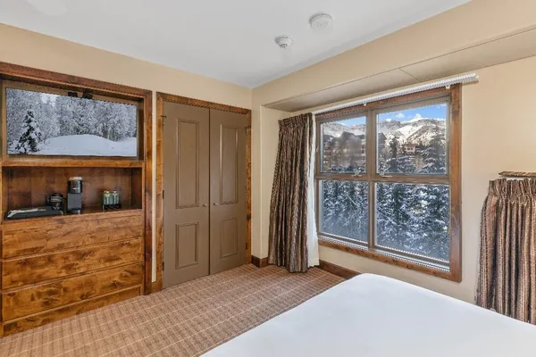 a bedroom with furniture and large window