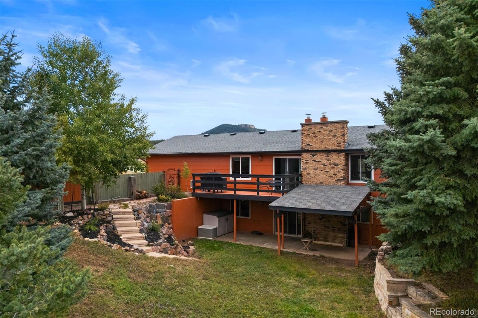 4466 West Parkridge Road Sedalia, CO 80135 - Photo 22 of 23 a view of a big house with table and chairs under an umbrella