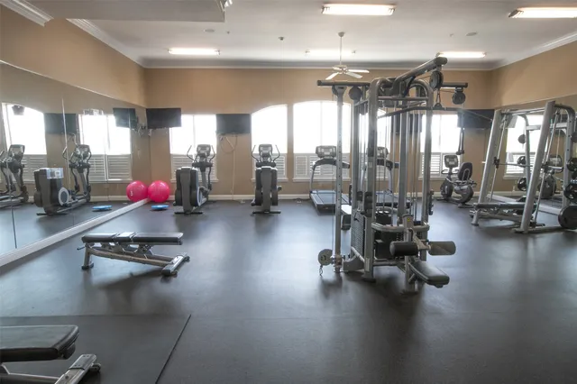 a gym room with gym equipment and a large window
