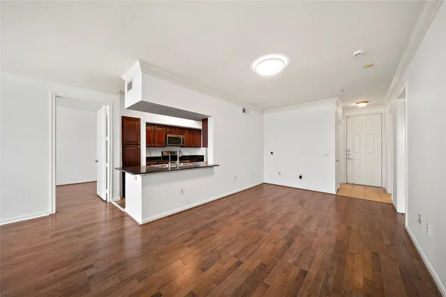 a view of a room with wooden floor and a flat screen tv