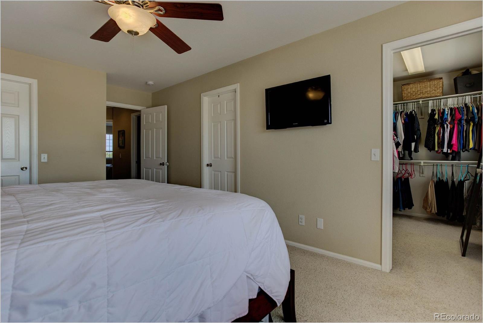 1021 Riddlewood Road Highlands Ranch, CO 80129 - Photo 16 of 29 a bedroom with a bed and a flat screen tv