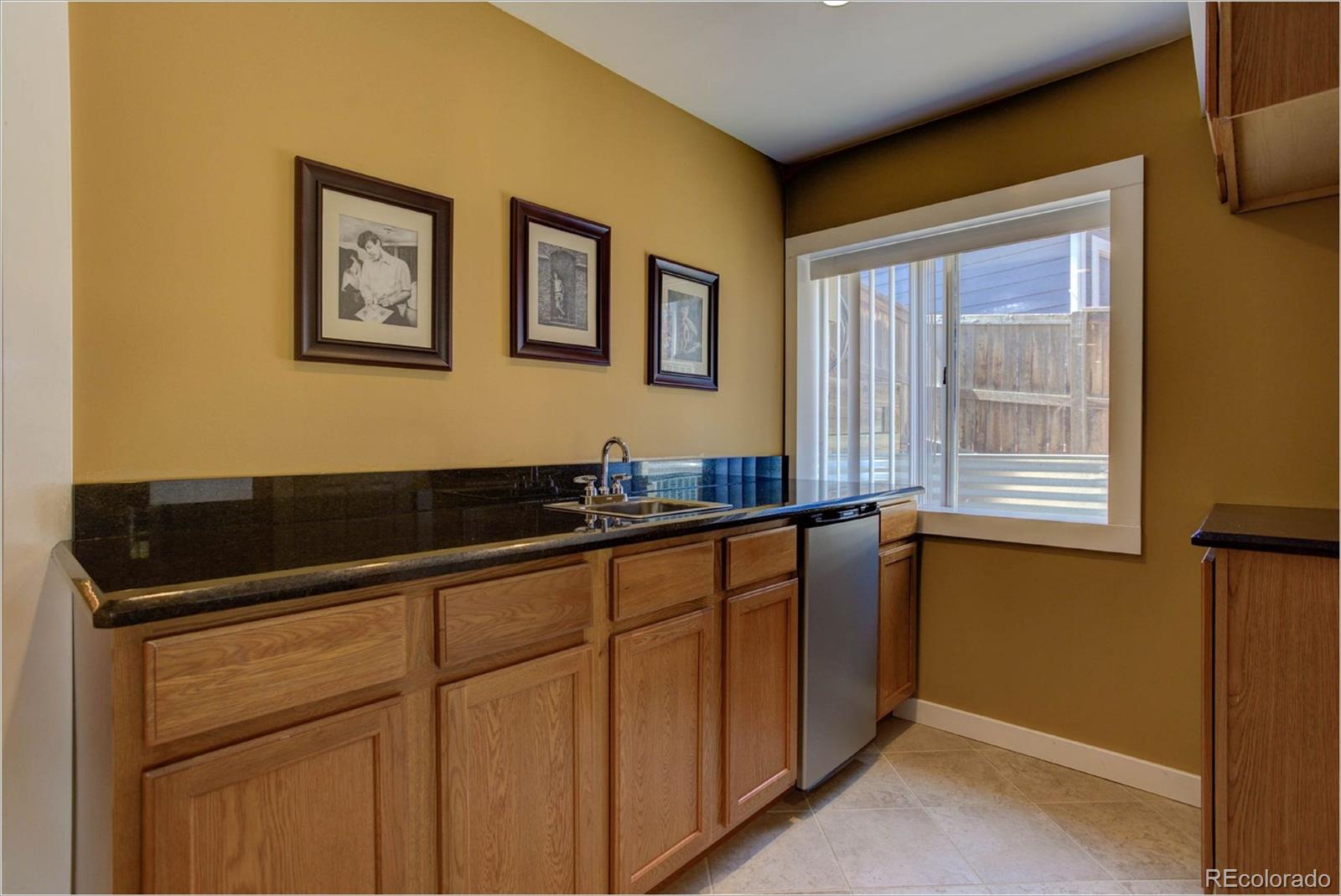 1021 Riddlewood Road Highlands Ranch, CO 80129 - Photo 20 of 29 a kitchen with granite countertop white cabinets and black stainless steel appliances