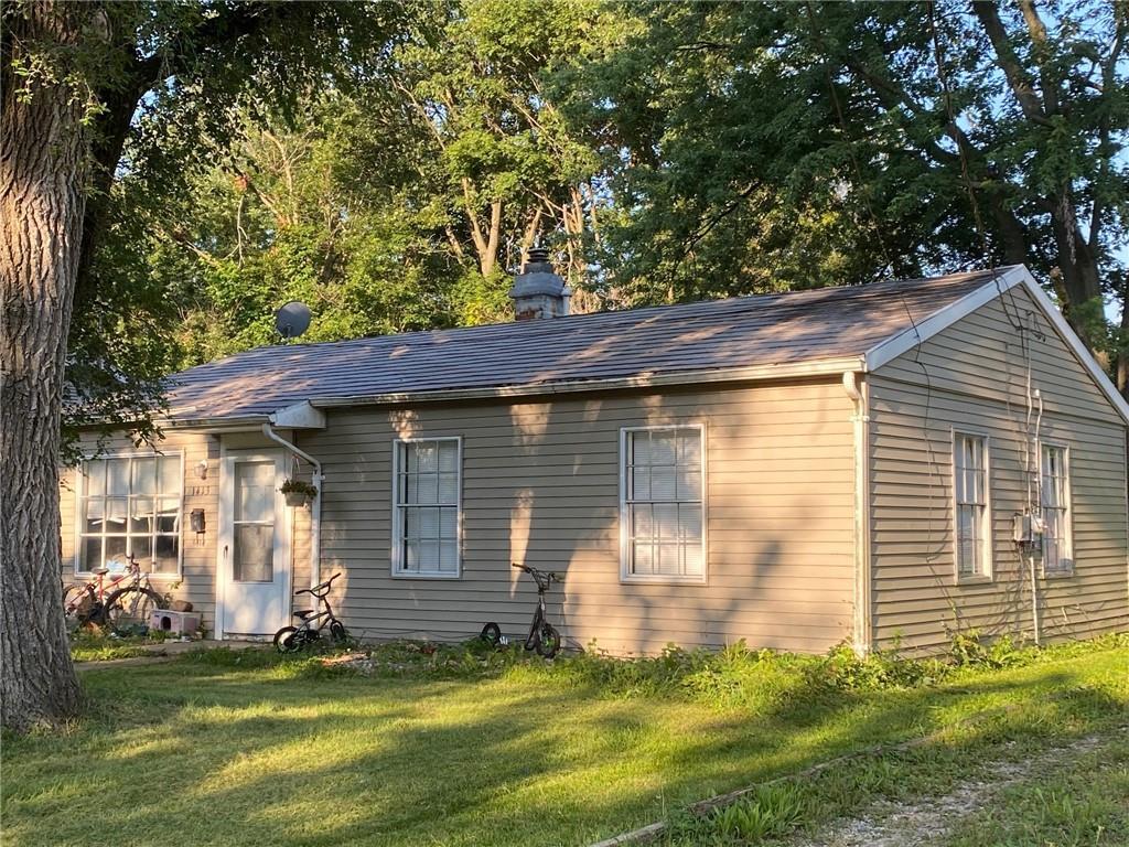 a view of a backyard with table and chairs and large tree