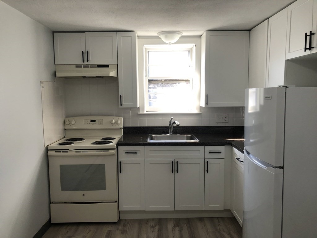 103 Trapelo Road, Unit 23 Waltham, MA 02452 - Photo 2 of 17 a kitchen with a stove a refrigerator and a sink