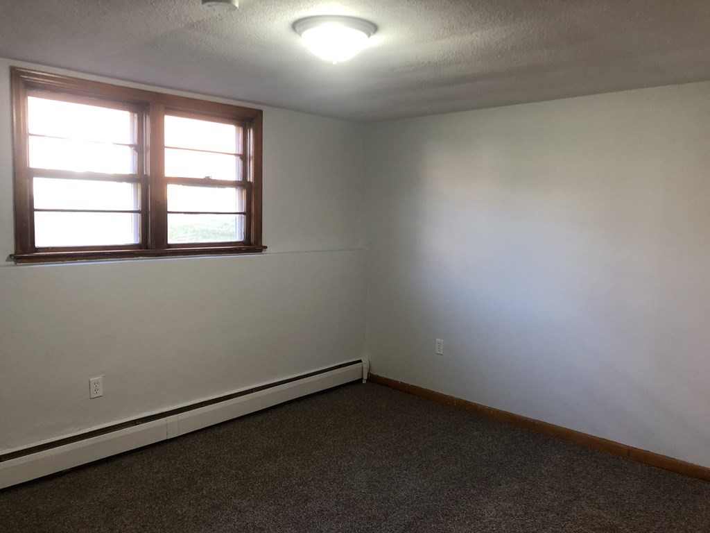 103 Trapelo Road, Unit 23 Waltham, MA 02452 - Photo 5 of 17 an empty room with a window