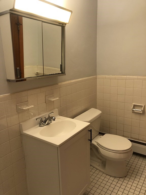 103 Trapelo Road, Unit 23 Waltham, MA 02452 - Photo 9 of 17 a bathroom with a sink a toilet and mirror