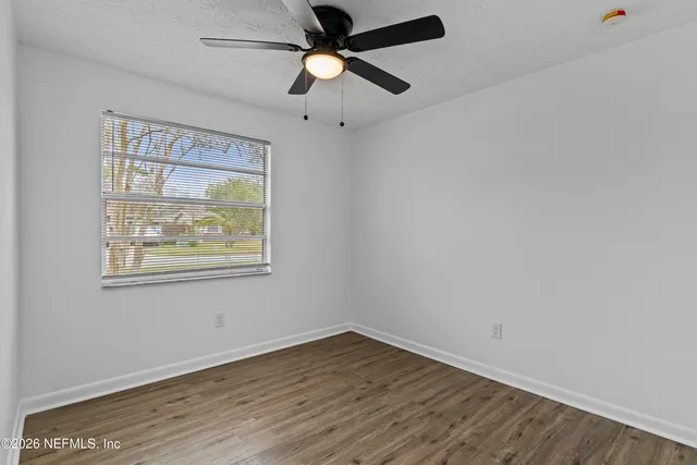 a view of an empty room with large windows and a table