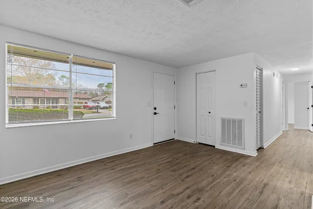 a view of an empty room with wooden floor