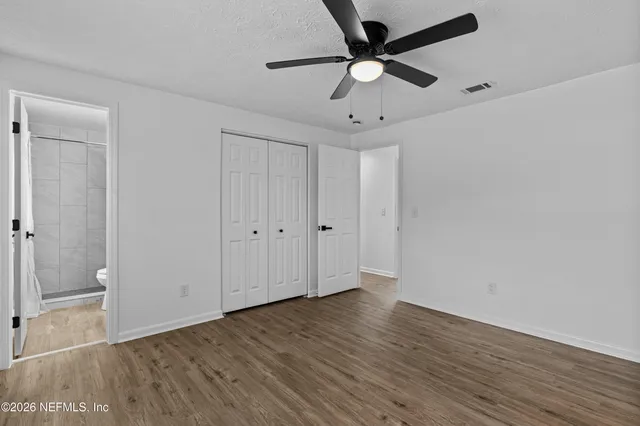 a view of a big room with wooden floor and a kitchen