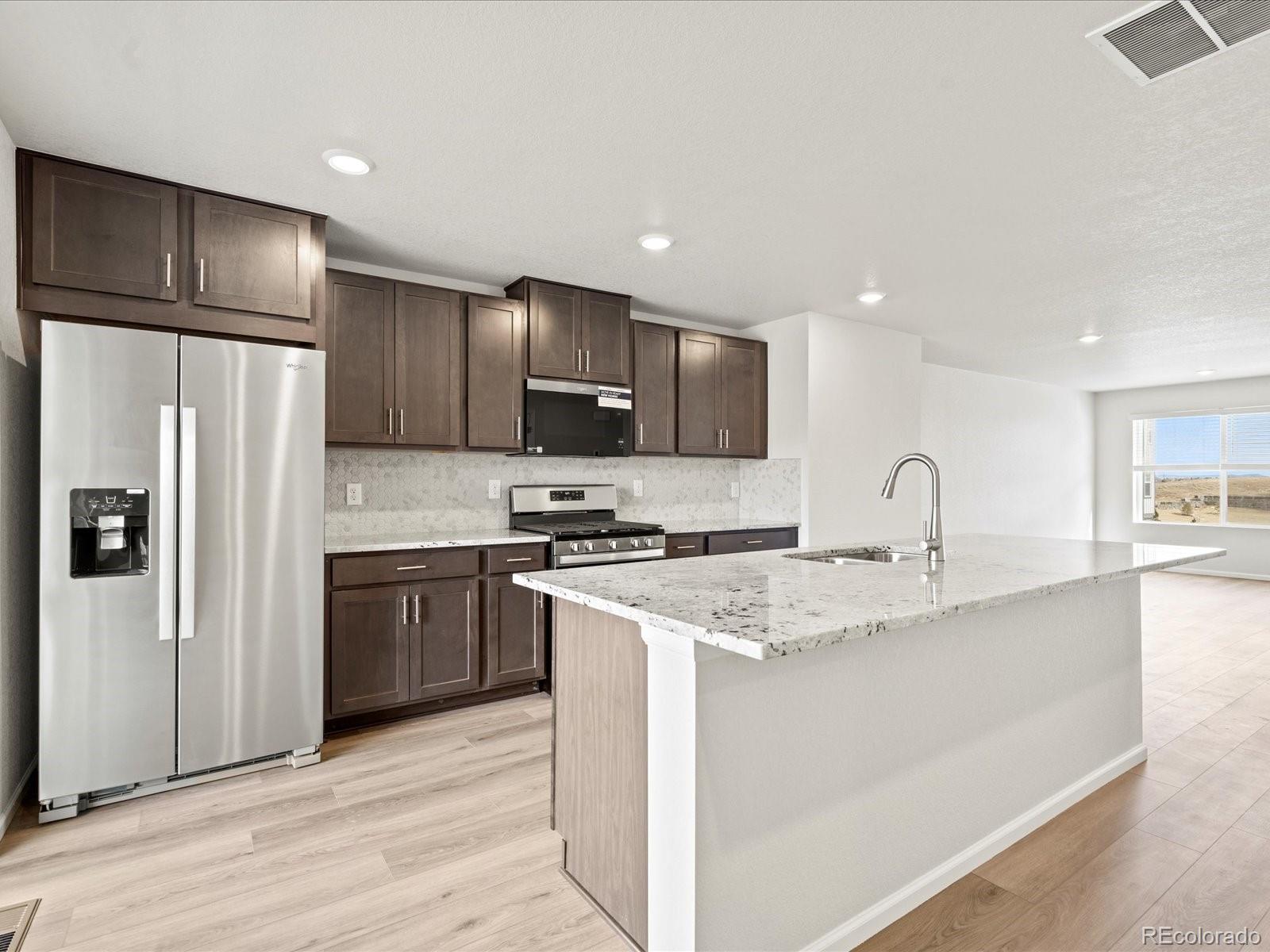 14412 Pansy Loop Morrison, CO 80465 - Photo 6 of 34 a kitchen with stainless steel appliances granite countertop a refrigerator sink and stove