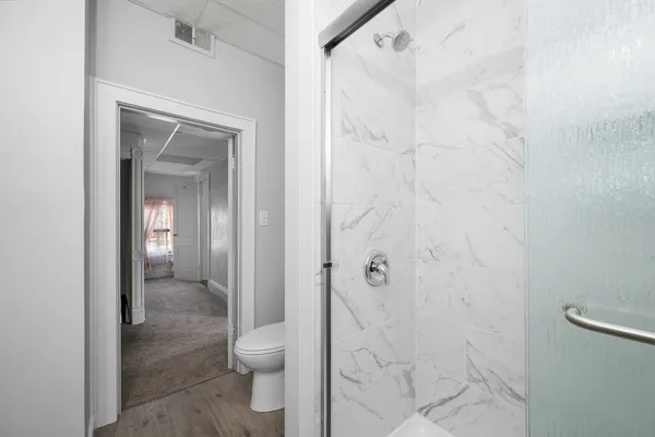 a bathroom with a granite countertop shower and a toilet