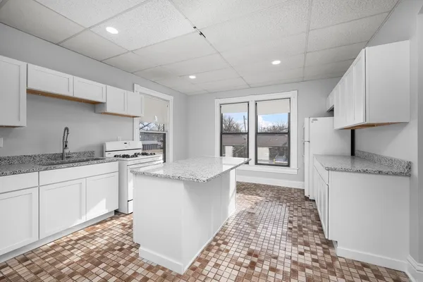 a large kitchen with stainless steel appliances granite countertop a sink stove and cabinets
