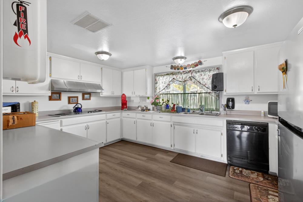 7460 Azimuth Lane, Unit 253 Sacramento, CA 95842 - Photo 42 of 50 a kitchen with granite countertop a sink cabinets stainless steel appliances and a center island
