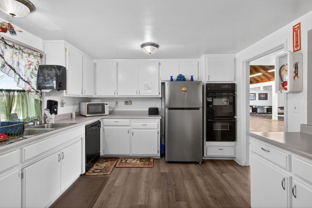 7460 Azimuth Lane, Unit 253 Sacramento, CA 95842 - Photo 43 of 50 a kitchen with a refrigerator sink and white cabinets