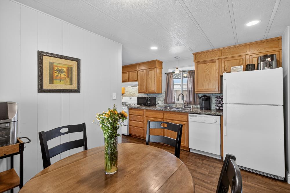 7460 Azimuth Lane, Unit 253 Sacramento, CA 95842 - Photo 10 of 50 a kitchen with stainless steel appliances granite countertop a refrigerator a stove a sink a dining table and chairs
