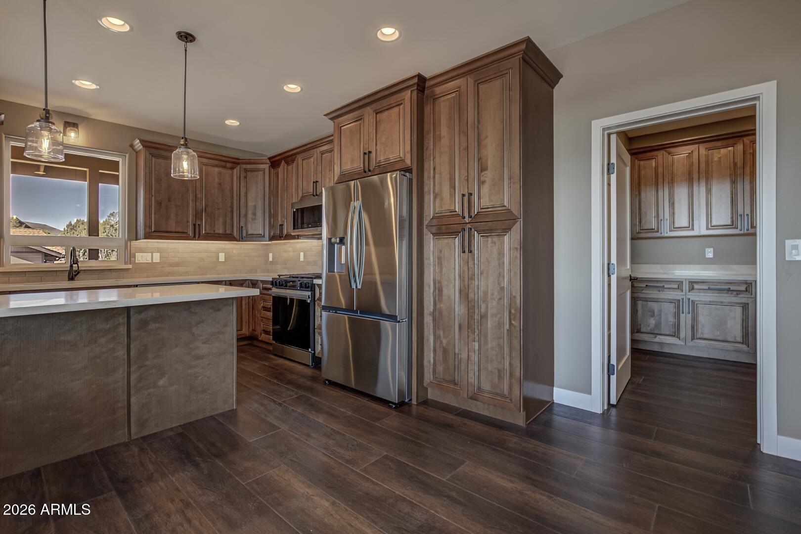504 North Wagon Court Payson, AZ 85541 - Photo 3 of 21 a kitchen with kitchen island a counter top space a sink and stainless steel appliances
