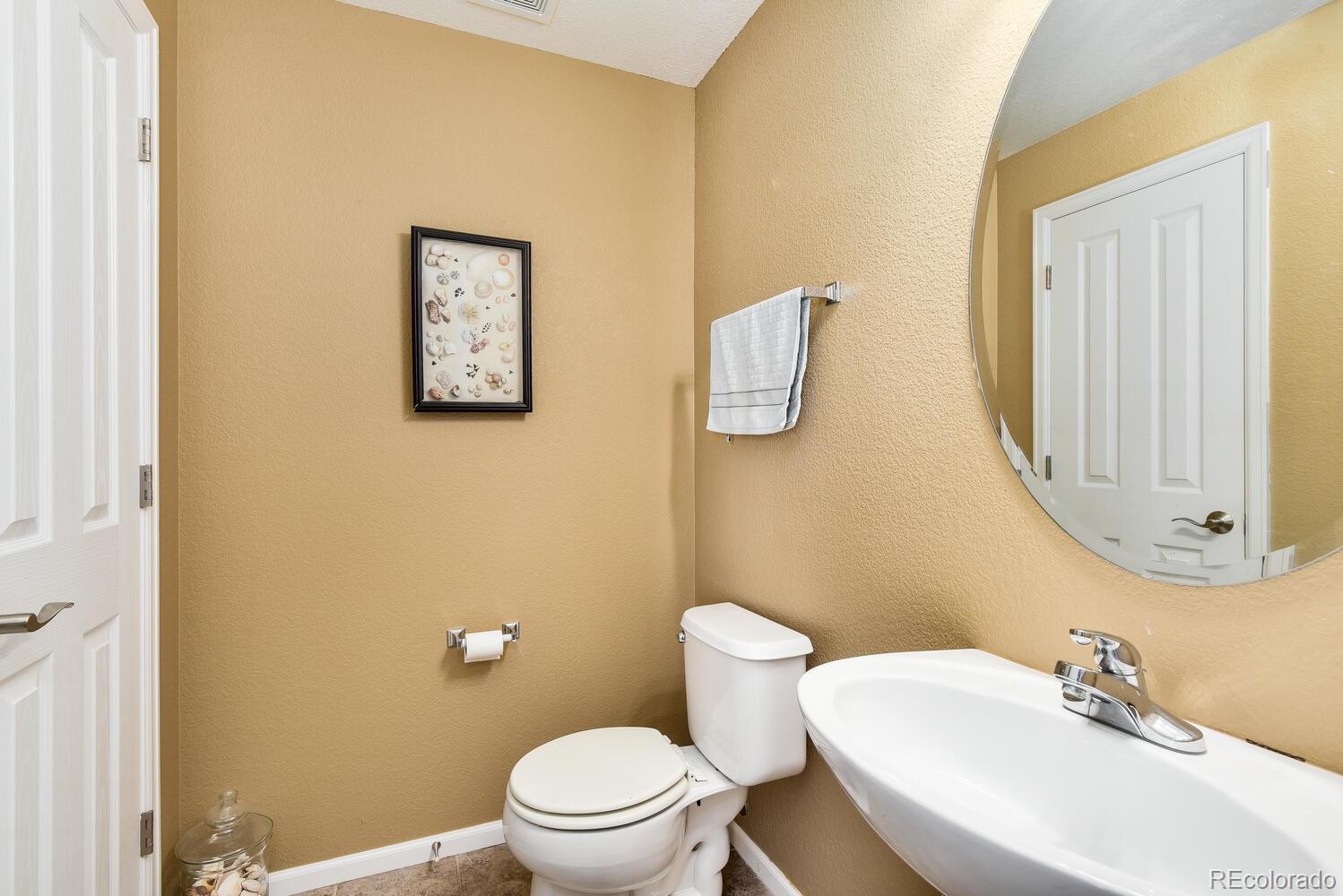 10842 Brooklawn Road Highlands Ranch, CO 80130 - Photo 13 of 35 a white toilet sitting next to a bathroom sink