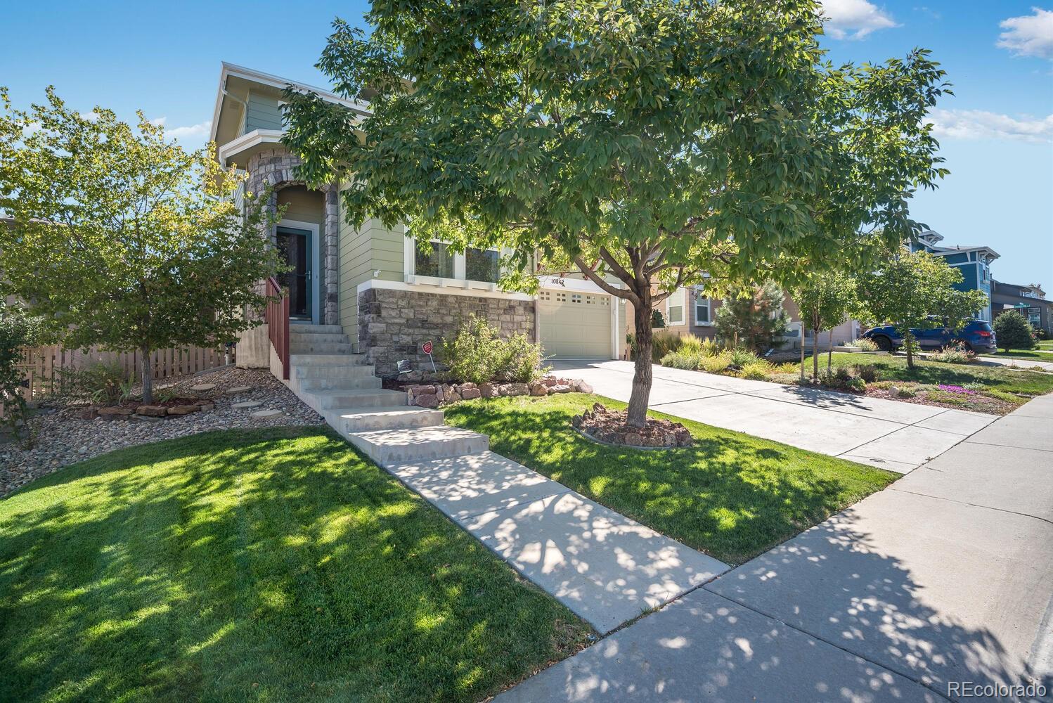 10842 Brooklawn Road Highlands Ranch, CO 80130 - Photo 2 of 35 a front view of a house with garden