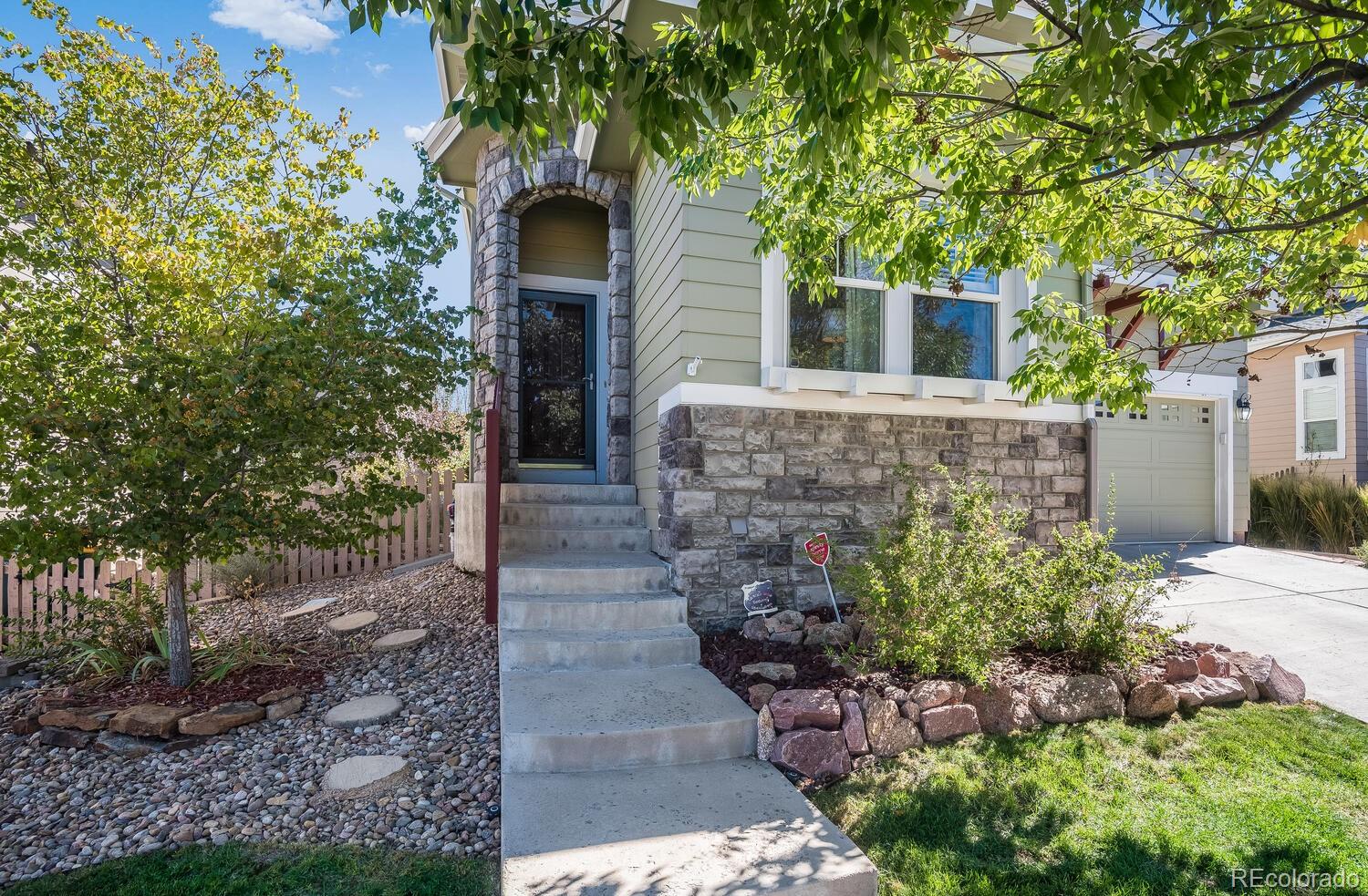 10842 Brooklawn Road Highlands Ranch, CO 80130 - Photo 3 of 35 a front view of a house with plants and garden