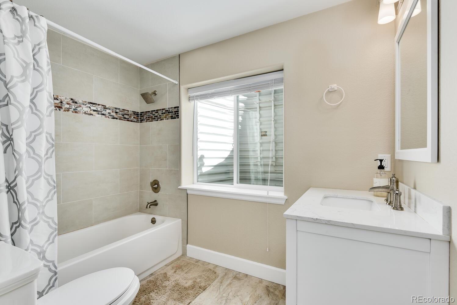 10842 Brooklawn Road Highlands Ranch, CO 80130 - Photo 32 of 35 a bathroom with a sink a toilet a mirror a bathtub and shower