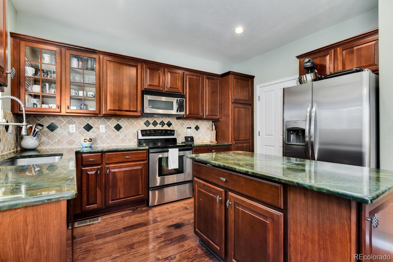 10842 Brooklawn Road Highlands Ranch, CO 80130 - Photo 10 of 35 a kitchen with stainless steel appliances granite countertop a refrigerator a stove top oven a sink and dishwasher