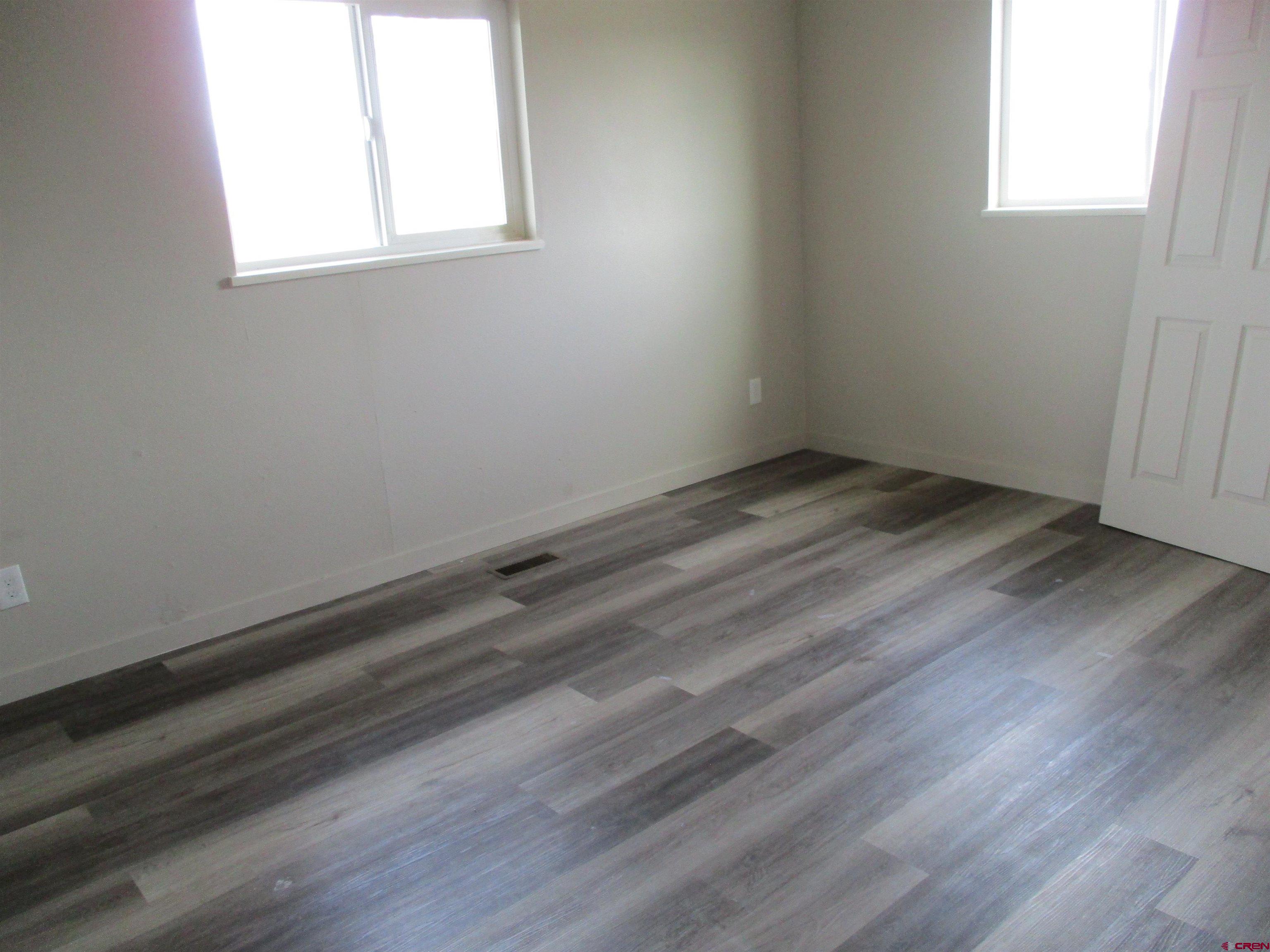 18950 Beaver Road Delta, CO 81416 - Photo 7 of 10 an empty room with wooden floor and windows