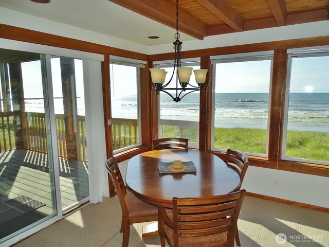 a view of a dining room with furniture large windows and wooden floor