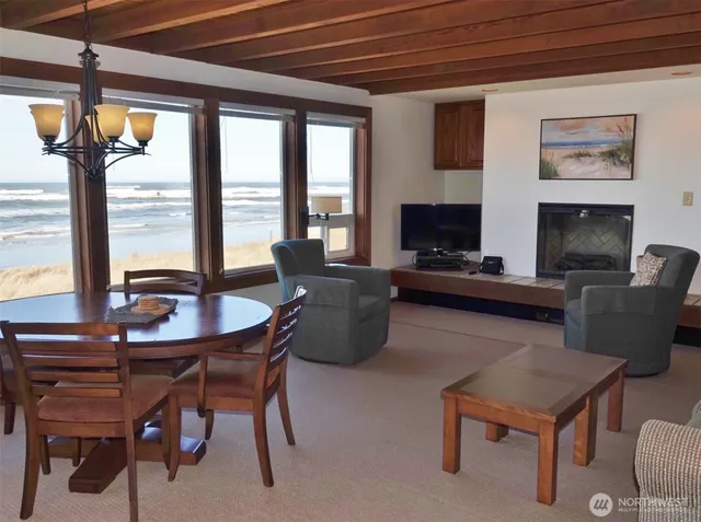 a living room with furniture a flat screen tv and a floor to ceiling window