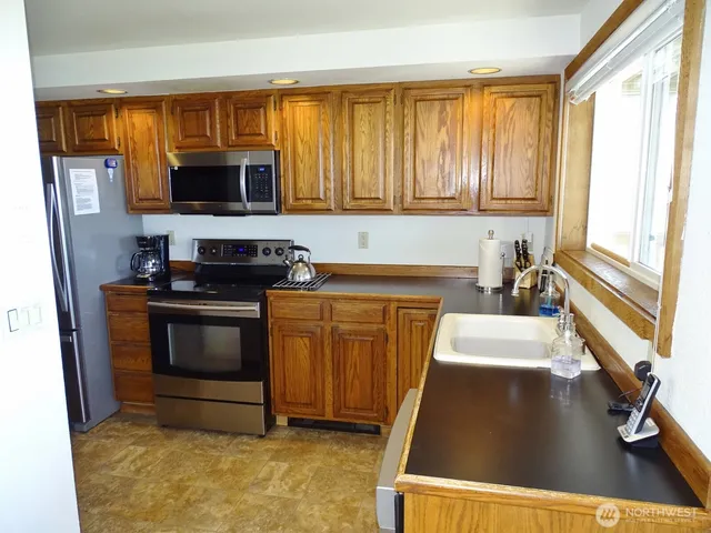 a kitchen with stainless steel appliances granite countertop a stove a sink and a microwave